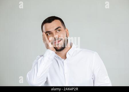 Minded bärtigen glückliche junge Mann träumt etwas Stockfoto