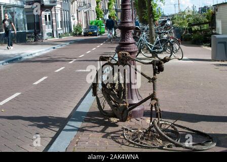 Altes Fahrrad wird mitten auf der Straße verrostet Stockfoto