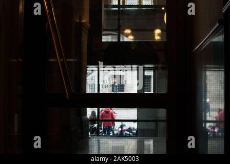 Steigen Sie die Treppe in einem Gebäude hoch, das nach außen zu den Straßen blickt Stockfoto