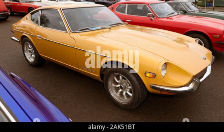 Drei Viertel Vorderansicht eines 1971, Orange, Datsun 240Z, die in der Auto Club Zone der Silverstone Classic 2019 Stockfoto