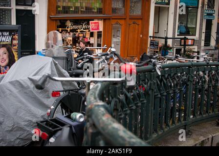 Geparkt Fahrrad Green Grid der Brücke und auf der Rückseite die Menschen passieren mit Restaurant und Café Stockfoto