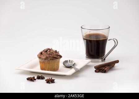 Chocolate Muffin mit heißen Tasse Kaffee, Zimtstangen und Anis Sterne auf weißem Hintergrund Stockfoto