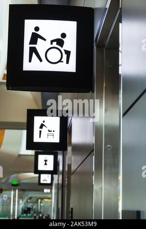 Beleuchtetes Zeichen für eine behinderte/wc Anlage in Hamad Flughafen, Katar Stockfoto