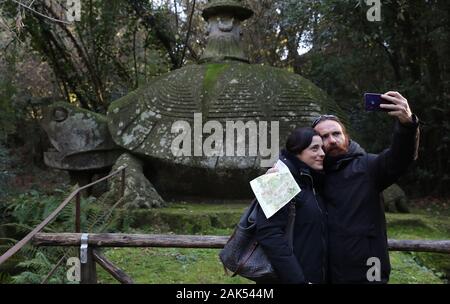 Bomarzo, Italien. 3 Jan, 2020. Die Menschen nehmen eine selfie im Park der Monster in Bomarzo, Italien, Jan. 3, 2020. Bomarzo, einem Dorf in der Region Latium am Fuße des Monte Cimino, besitzt ein einzigartiges Werk, das Haus der Wunder, auch genannt der Heilige Wald oder Park der Monster.lt wurde von Herzog von Bomarzo, Vicino Orsini konstruiert und Architekten Pirro Ligorio 1552. Dieses italieners Stil Garten folgt geometrische und Perspektive Rationalität mit Verzierungen wie breiten Terrassen, Brunnen mit Wasser spielen und Manieristischen Skulpturen. Credit: Cheng Tingting/Xinhua/Alamy leben Nachrichten Stockfoto