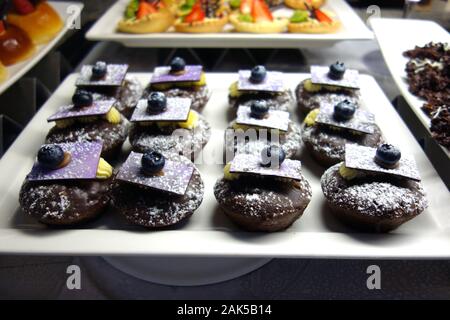 Kleine Früchte & Schokolade aufgefüllt Schwamm Kuchen am Frühstücksbuffet im Azul Beach Hotel, Puerto Morelos, Riviera Maya, Cancun. Mexiko. Stockfoto