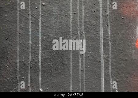 Strukturierte schwarze Wand mit weißer Farbe tropft. Zusammenfassung Hintergrund. Stockfoto