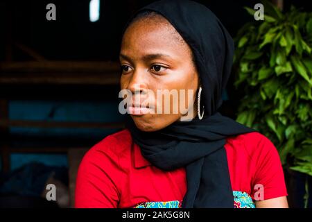 Schöne junge afrikanische Frau mit Schal und suchen seitwärts im Freien geraden Gesicht Stockfoto