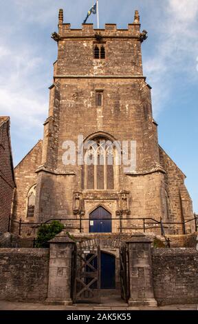 Corfe Castle, England, UK - 30. Juli 2011: Die Sonne scheint auf die traditionelle gotische Kirche Turm von St. Edward's Kirche in Corfe Castle, Dorset. Stockfoto