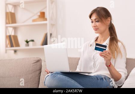 Online Shopping. Frau mit Laptop mit Kreditkarte kaufen und Kaufen im Internet Sitzen auf einem Sofa zu Hause. Stockfoto