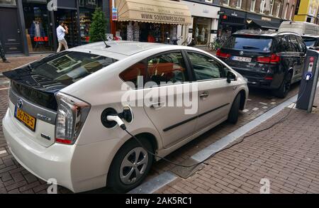 Amsterdam, Holland. August 2019. Auf der Straße ein Toyota Prius Plug-in laden geparkt ist. Die Ladebuchse ist in die appropria eingefügt Stockfoto