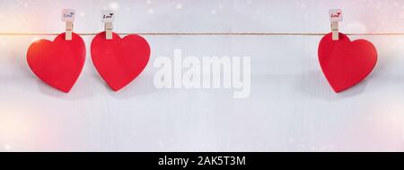Drei rote Herzen auf String mit weißem Hintergrund. Valentinstag Konzept. Platz für Text Stockfoto