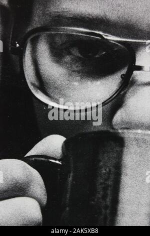 Feine Schwarzweißfotografie der 1970er Jahre einer Frau, die eine Brille trägt und die Kamera betrachtet Stockfoto