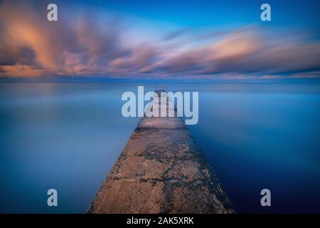 Lange Belichtung seascape Fine Art Foto von Pier auf ein Sonnenaufgang in Paphos, Zypern Stockfoto