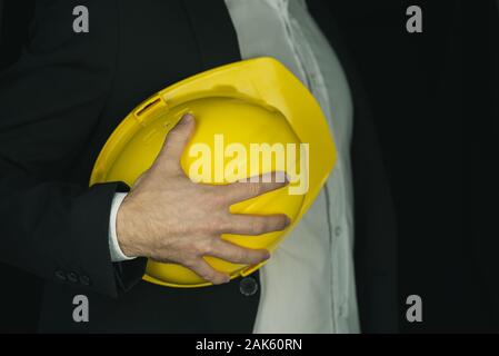 Detailansicht des Auftragnehmers in einem Anzug mit leuchtend gelben Arbeitsschutzausrüstungen Helm. Stockfoto