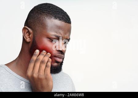 Junge traurig schwarzer Mann in Schmerz in seiner Zähne, Zahnschmerzen Konzept, freier Speicherplatz Stockfoto