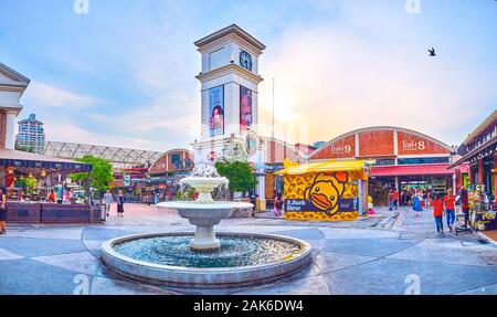 BANGKOK, THAILAND - 15 April, 2019: Der kleine Brunnen in Town Square Bezirk Asiatique sun Shopping Park ist umgeben von malerischen Fassaden von Restaurants Stockfoto