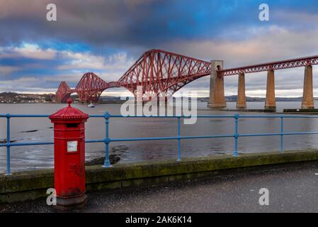 Ein viktorianisches Penfold roten Briefkasten im South Queensferry mit Blick auf die Forth Bridge. Stockfoto