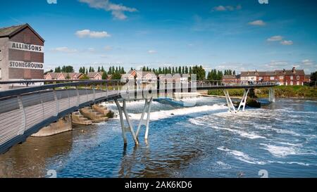 Millenium Bridge mit Allisons Stonefround Mehl Mill am Wehr in Castleford, Yorkshire Stockfoto