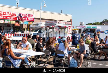 West Islip, New York, USA - 22. September 2019: Leute an den Tischen genießen das Essen in einer lokalen Gemeinschaft Messe sitzen. Stockfoto