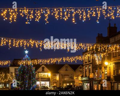 Weihnachtsbaum und Lichterketten drapiert über den Marktplatz in der Dämmerung in den Knaresborough North Yorkshire England Stockfoto
