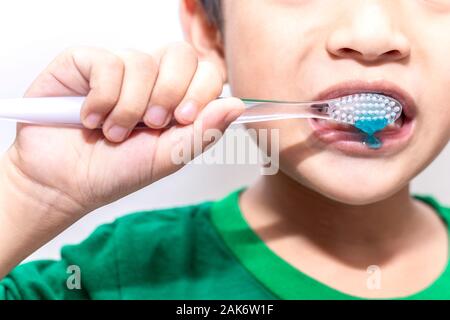 Kleine asiatische Junge mit Zahnbürste reinigen von Zähnen im Bad. Close up Kid seine Zähne putzen. Gesundheitswesen und zahnmedizinische Hygiene Konzept. Stockfoto