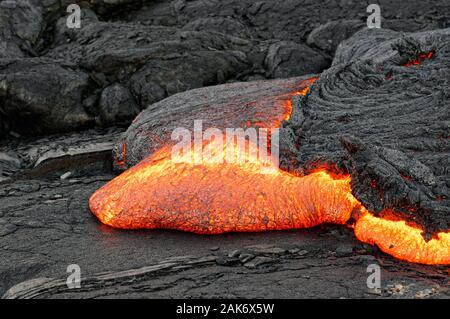 Detailansicht eines aktiven Lavastrom, heißem Magma entsteht aus einem Riss in der Erde, die glühende Lava erscheint in kräftigen Gelb- und Rottöne - Ort: Haw Stockfoto