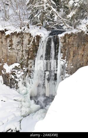 Eine schöne gefrorenen Wasserfall im Winter in einer verschneiten Landschaft Stockfoto