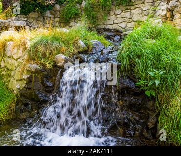 Schönen Garten Architektur, kleiner Wasserfall Streaming über Felsen, Natur Hintergrund Stockfoto