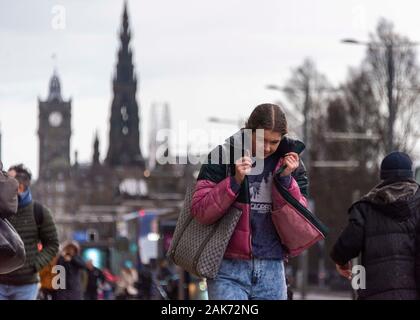 Dienstag, 7. Januar 2020: Fußgänger auf Edinburgh's Princes Street Schlacht starken Winden. Schottland war mit starken Winde mit Böen von bis zu 75 mph Hit Stockfoto