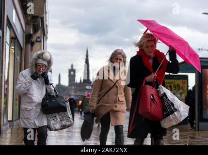 Dienstag, 7. Januar 2020: Fußgänger auf Edinburgh's Princes Street Schlacht starken Winden. Schottland war mit starken Winde mit Böen von bis zu 75 mph Hit Stockfoto