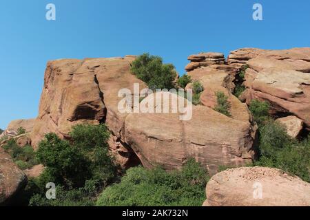 Große rote Felsen Sandstein Felsformationen mit Bäumen wachsen in den Spalten der Felsen auf der Trading Post Trail in Red Rocks Park, Colorado, USA Stockfoto