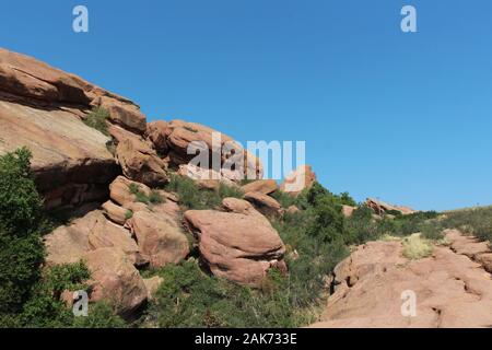 Große rote Felsen Sandstein Felsformationen mit Bäumen wachsen in den Spalten der Felsen neben dem Trading Post Trail in Red Rocks Park, Colorado, USA Stockfoto