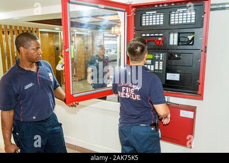 Miami Beach Florida, Präsidentschafts-Wohnanlagen, schwarzafrikanische Afrikaner, Hispanic Feuerwehrmann, Feuerwehrmänner, Feuerwehrmann, mögliches Feuer lokalisieren, Alarmanlage, FL10062 Stockfoto