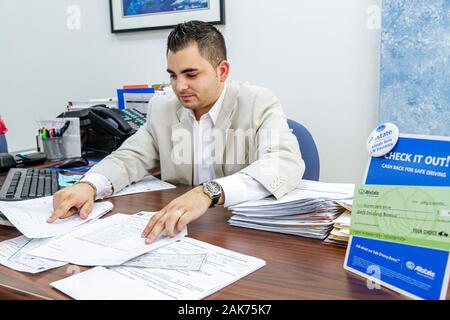 Miami Beach, Florida, Versicherungsbüro der Allstate, Hispanic-Mann, Männer, Agent, Schreibtisch, arbeiten, arbeiten, arbeiten, arbeiten, Arbeitnehmer Arbeitnehmer, Mitarbeiter, FL100620 Stockfoto