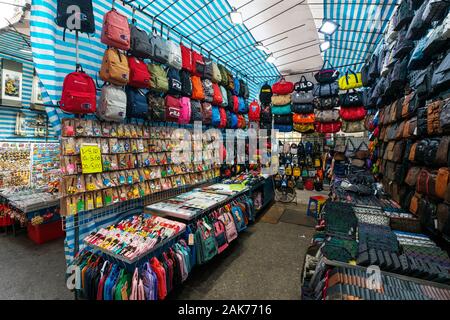 HongKong, China - November, 2019: Taschen, Rucksäcke und Kleidung auf der Straße Ladie's Market (Markt) in Hongkong, Tung Choi Street Stockfoto