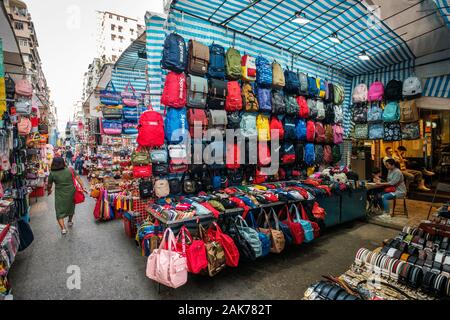 HongKong, China - November, 2019: Taschen, Rucksäcke und Kleidung auf der Straße Ladie's Market (Markt) in Hongkong, Tung Choi Street Stockfoto