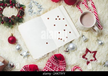 Blick von oben auf die Papier Hinweis für das neue Jahr Ziele und Beschlüsse Liste mit Weihnachtsschmuck Stockfoto