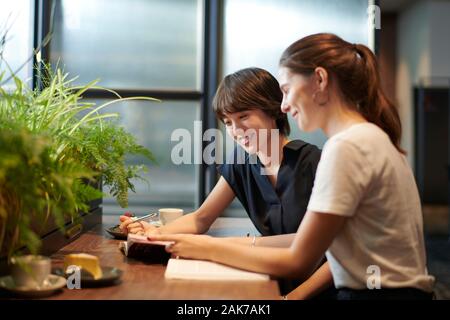 Junge Freundinnen in einem Cafe Stockfoto