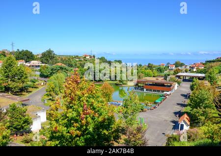 Santana, Madeira, Portugal - Sep 24, 2019: Blick auf die Madeira Themenpark. Grüne Bäume, See, Häuser und Wanderwege. Messegelände auf den portugiesischen Inseln gewidmet. Stockfoto