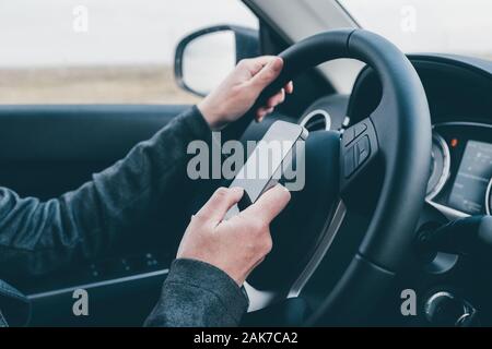 Texting und Fahren ist gefährlich Verhalten im Verkehr, in der Nähe der weiblichen Hand Eingeben von SMS auf Handy, während sie durch die Landschaft zu reisen Stockfoto