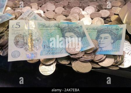 Geld ist in einer "Coin Pusher 'arcade spiel in Swanage, Dorset, November 2019 gesehen. Stockfoto