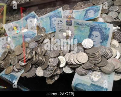 Geld ist in einer "Coin Pusher 'arcade spiel in Swanage, Dorset, November 2019 gesehen. Stockfoto