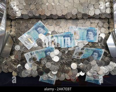 Geld ist in einer "Coin Pusher 'arcade spiel in Swanage, Dorset, November 2019 gesehen. Stockfoto