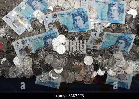 Geld ist in einer "Coin Pusher 'arcade spiel in Swanage, Dorset, November 2019 gesehen. Stockfoto