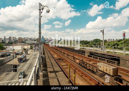 2020, Januar; Sao Paulo, Brasilien. Bahn rail Seite an Seite mit einer großen Straße mit Autos, in der Nähe der Portuguesa Tiete Metro Station. Stockfoto