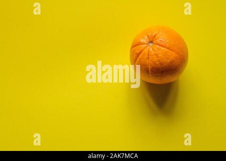 Ansicht von oben ganze Reife orange auf gelbem Untergrund, Konzept der Gesundheit und Vitamine Stockfoto