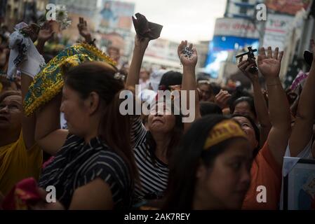 Die katholischen Gläubigen reagieren als Priester sprengen Weihwasser auf die Masse während der Parade. Tausende von Römisch-katholischen Gläubigen nehmen an einer Parade vor dem Fest des Schwarzen Nazareners in Manila, Philippinen. Millionen wird erwartet, dass der Höhepunkt des Festes am 9. Januar, wo die katholischen Gläubigen vie wird eine lebensgroße Skulptur eines dunkelhäutigen Jesus Christus - die schwarzen Nazareners - zu berühren, da es durch die Straßen von Manila marschierten zu verbinden. Auf den Philippinen ist eine von nur zwei katholischen Mehrheit Länder in Südostasien, neben Osttimor. Stockfoto