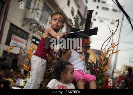 Ein Kind reagiert während der Parade. Tausende von Römisch-katholischen Gläubigen nehmen an einer Parade vor dem Fest des Schwarzen Nazareners in Manila, Philippinen. Millionen wird erwartet, dass der Höhepunkt des Festes am 9. Januar, wo die katholischen Gläubigen vie wird eine lebensgroße Skulptur eines dunkelhäutigen Jesus Christus - die schwarzen Nazareners - zu berühren, da es durch die Straßen von Manila marschierten zu verbinden. Auf den Philippinen ist eine von nur zwei katholischen Mehrheit Länder in Südostasien, neben Osttimor. Stockfoto