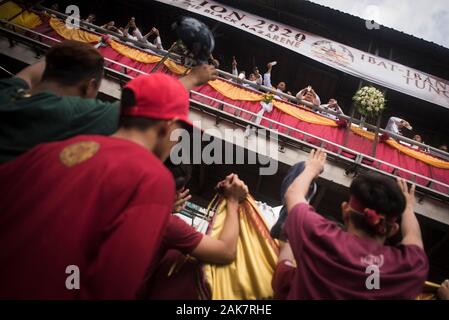 Priester sprengen Weihwasser auf die Masse während der Parade. Tausende von Römisch-katholischen Gläubigen in einer Parade vor dem Fest des Schwarzen Nazareners in Manila, Philippinen. Millionen wird erwartet, dass der Höhepunkt des Festes am 9. Januar, wo die katholischen Gläubigen vie wird eine lebensgroße Skulptur eines dunkelhäutigen Jesus Christus - die schwarzen Nazareners - zu berühren, da es durch die Straßen von Manila marschierten zu verbinden. Auf den Philippinen ist eine von nur zwei katholischen Mehrheit Länder in Südostasien, neben Osttimor. Stockfoto