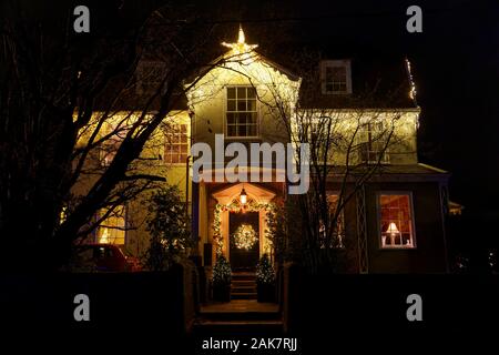 Haus in der Nacht mit Weihnachtsdekorationen rund um die Haustür Stockfoto